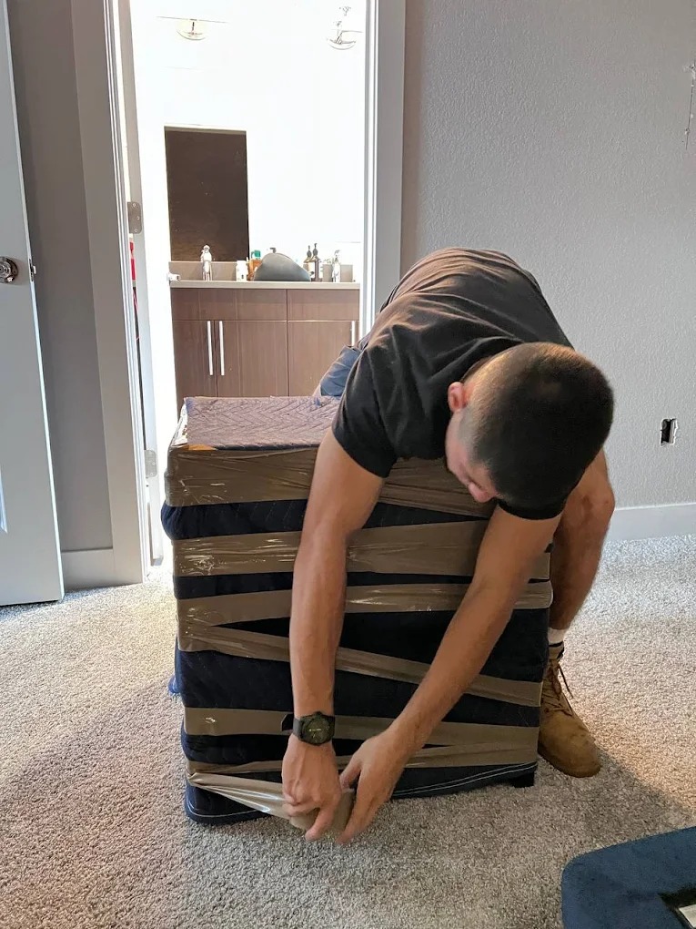 Professional long distance movers from PackPalTeam carefully loading furniture into a moving truck in Round Rock, TX